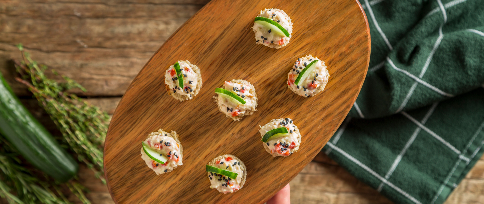 Tábua de mini sanduíches abertos de frango com pepino