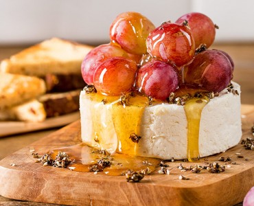 Queijo branco com uvas, crocante de fibras, mel e pão integral