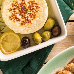 Queijo com azeite, azeitonas e limão, servido com pão integral