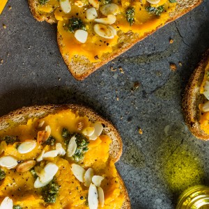 Sanduíche aberto com pasta de moranga, pesto e amêndoas