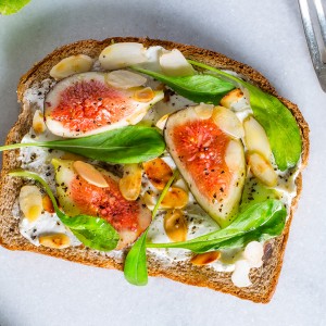 Bruschetta de figo caramelado, mini rúcula e amêndoas