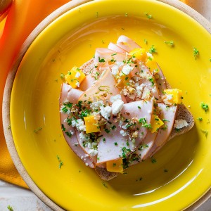 Sanduíche aberto de peru, gremolata, manga e nozes